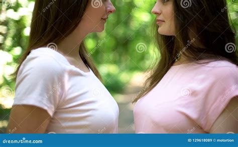 young girls kissing|Passionate lesbian girls kissing each other outside with lens.